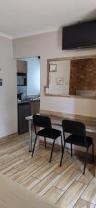 a kitchen with two chairs and a table in a room at Twins Guest House Astoni in Vanderbijlpark