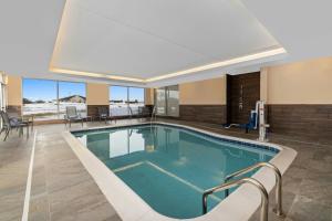 a pool in a hotel with chairs and tables at Fairfield Inn & Suites Dixon in Dixon