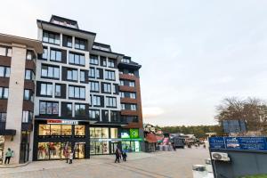 a building on a street with people walking in front of it at PANTEX Centar Zlatibor in Zlatibor
