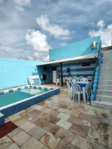 a patio with a table and chairs next to a swimming pool at Casa de temporada 08 Pessoas PISCINA LAZER Entretenimento pra família in João Pessoa