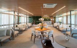 a restaurant with tables and chairs and windows at Luxury Flat with Breakfast! in Ipojuca