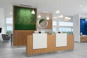 a lobby with two reception desks and a green wall at Element by Marriott Opelika Auburn in Opelika +43 photos