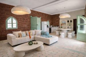 a living room with a white couch and a table at Villa Al Firdaous in Tiznit