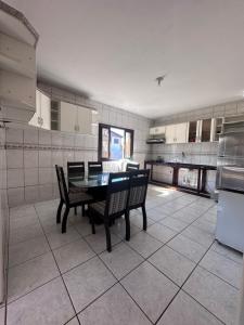 a large kitchen with a table and chairs in it at Casa Vila Nova Alvorada in Imbituba