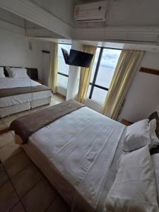 a bedroom with two beds and a large window at tropical Flat Belissimo in Manaus