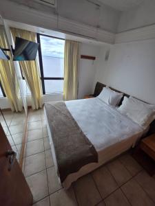 a bedroom with a large bed and a large window at tropical Flat Belissimo in Manaus