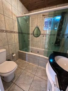 a bathroom with a toilet and a sink and a shower at Casa Vila Nova Alvorada in Imbituba +29 photos