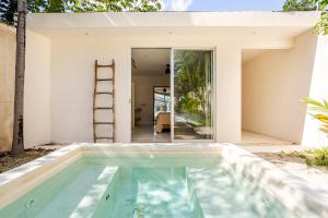 a swimming pool in front of a house with a ladder at 11BR I Hacienda Zalama in Tulum
