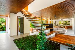 a living room with a staircase in a house at 11BR I Hacienda Zalama in Tulum