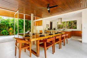 a dining room with a large wooden table and chairs at 11BR I Hacienda Zalama in Tulum