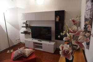 a living room with a tv and a vase with flowers at Villa Castaldi Firenze vicina al centro in Florence +29 photos