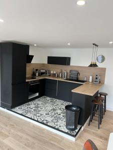 a kitchen with black cabinets and a counter top at Appartement neuf & élégant Centre Dunkerque rue de la porte d'eau in Dunkerque