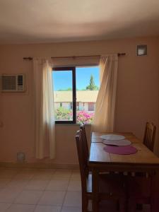 a dining room with a table and a window at Departamento espiral in Embalse