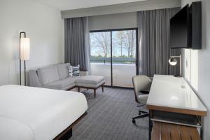 a hotel room with a bed and a living room at Courtyard by Marriott Huntsville University Drive in Huntsville