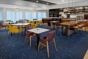 a restaurant with tables and chairs and a counter at Courtyard by Marriott Huntsville University Drive in Huntsville