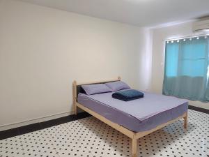 a bedroom with a bed with purple sheets and a window at Bangkok villa with 3 bedrooms in Ban Zong Katiam
