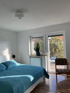 a bedroom with a blue bed and a window at Stilvolles Studio im Allgäu in Rettenbach am Auerberg