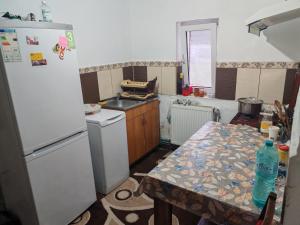 a kitchen with a table and a white refrigerator at CasaLoco in Mediaş