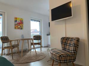 a living room with a table and chairs and a tv at Stilvolles Studio im Allgäu in Rettenbach am Auerberg