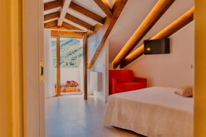 a bedroom with a bed and a red chair at Le Perseidi in Agerola