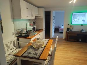 a kitchen with a table and a dining room with a television at Apartament in Rabka-Zdrój
