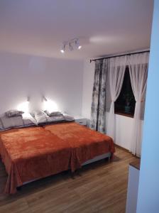 a bedroom with a bed with a orange blanket at Apartament in Rabka-Zdrój