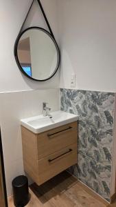 a bathroom with a sink and a mirror on the wall at Maison Ty Bian Prieuré in Pleubian
