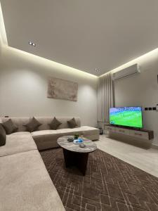 a living room with a couch and a tv at شقة فاخرة in Al Kharj