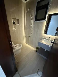 a bathroom with a toilet and a sink and a shower at شقة فاخرة in Al Kharj
