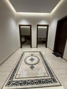 a room with a rug on the floor with three doors at شقة فاخرة in Al Kharj