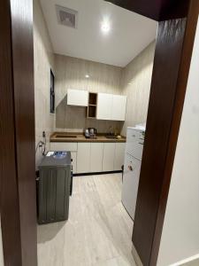a kitchen with white cabinets and a refrigerator at شقة فاخرة in Al Kharj