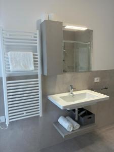 a bathroom with a sink and a mirror and towels at Matilde Apartments Caorle in Caorle +45 photos
