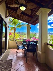 a patio with a table and chairs on a porch at Breezy Paradise 2 bed2bath with mountain view in Coco