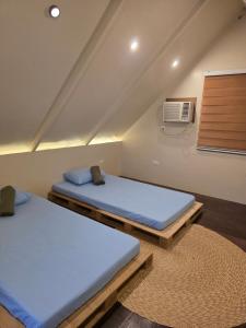 a bedroom with two beds and a air conditioner at Romantic Ocean View A-Frame with Shore Diving Access - Aloha Aina Dive Resort in Mabini