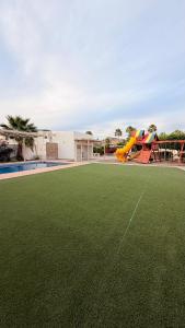 a playground with a slide on a grass field at Sunset Point San Carlos in San Carlos