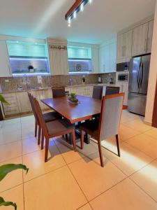 a large kitchen with a wooden table and chairs at Sunset Point San Carlos in San Carlos