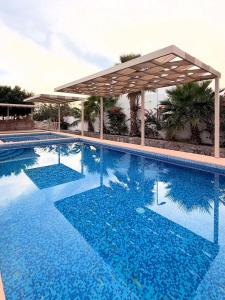 a large blue swimming pool with a pavilion at Sunset Point San Carlos in San Carlos