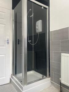a shower with a glass door in a bathroom at Contractor House with parking in Worksop +8 photos