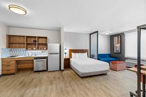 a hotel room with a bed and a kitchen at Everhome Suites Temecula Wine Country in Temecula