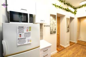 a kitchen with a tv on top of a refrigerator at MMRent Divine Room in Gdańsk