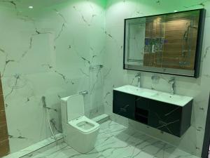 a bathroom with a toilet and a sink and a mirror at Résidence Salt Lake in Pikine