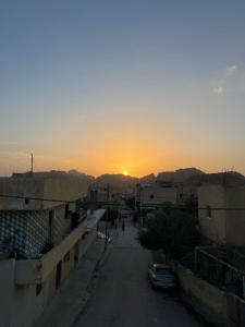 a sunset over a city with a street and buildings at Eman house in Wadi Musa