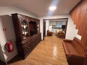 a living room with a couch and a large entertainment center at Refugio do Alto de Levira in Anadia
