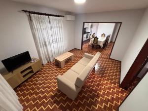 a living room with a white couch and a television at Refugio do Alto de Levira in Anadia
