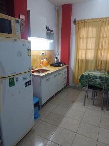 a kitchen with a white refrigerator and a table at Laura in Rosario