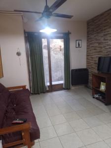 a living room with a couch and a ceiling fan at Laura in Rosario