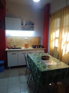 a kitchen with a table with a green table cloth on it at Laura in Rosario