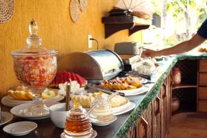 a buffet line with plates of food on a counter at Pousada Sol e Luna - Pipa Garden in Pipa +61 photos