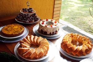 a table with several cakes and pies on plates at Pousada Sol e Luna - Pipa Garden in Pipa