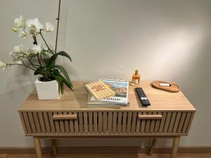 a table with a vase of flowers and a book at Luméa 126 in Éguilles